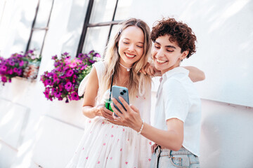 Two young beautiful smiling hipster female in trendy summer clothes. Carefree women posing...