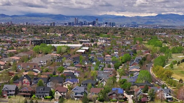 Front Range Denver Lowry Northfield Central Park Colorado aerial drone summer spring green blossom neighborhood condo apartment buildings sunny cloudy sky cars cityscape skyscrapers forward pan up