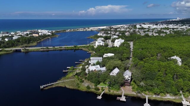 Panoramic drone fly over the luxury residential houses at Camp Creek Lake with County Rd 30A highway, 30A, Florida, USA