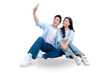 A cheerful couple taking a selfie and looking delighted. The two people are sitting together, both wearing casual clothes, and smiling warmly on PNG background