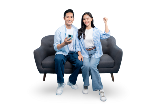 A happy couple is sitting on a couch, with one holding a mobile phone. They are both smiling and are in casual clothing, in a well-lit environment on PNG background
