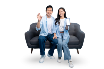 Happy couple smiling and showing mobile phone, ok gesture and sitting on couch. Couple with a phone smiling on PNG background