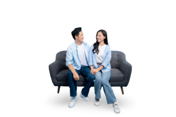 A young couple sitting on a comfortable sofa, smiling at each other, symbolizing love and togetherness on PNG background