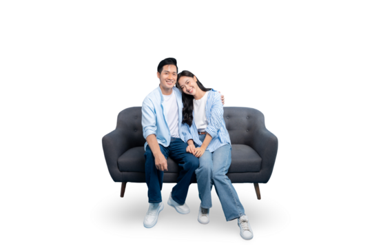 A couple sitting together on a couch smiling with hands together. The couple is on PNG background
