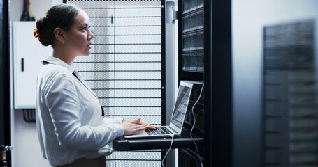 Laptop, typing and woman in server room for engineering, network maintenance or programming....