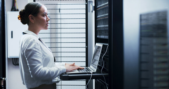 Laptop, typing and woman in server room for engineering, network maintenance or programming. Administration, computer and cybersecurity with IT professional in data center for firewall installation