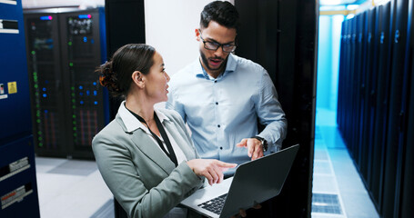Server room, team and people with laptop for discussion, diagnostics or networking. IT, technician and planning with computer in datacenter for cybersecurity, system maintenance or problem solving