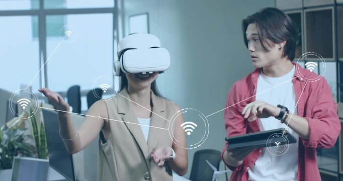 Female developer donning VR headset pulling Wi-Fi icons, engineer swiping tablet activating net map