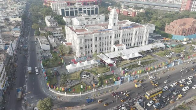 Drone view of Ripon Building highlighting its white colonial style architecture with nearby traffic roads and surrounding city structures.