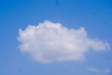 Cloud in a Blue Sky: A serene cloud drifts peacefully against a brilliant blue sky, embodying tranquility, freedom, and the boundless expanse of the atmosphere.