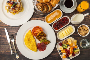 Delicious breakfast set with pancakes, omelet, croissants and fruits