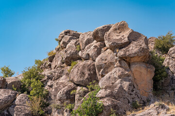 Natural rock formation with clear sky and vegetation