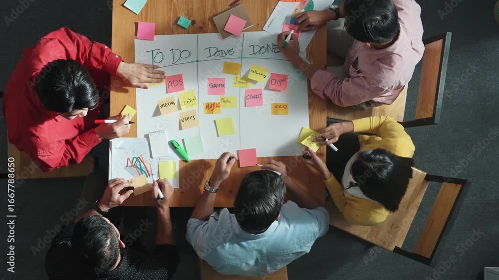 Aufkleber Top view of people writing and making scrum task board while writing marketing and planning strategy at colorful sticky notes. Smart team manage work performance by using kanaban board. Convocation.