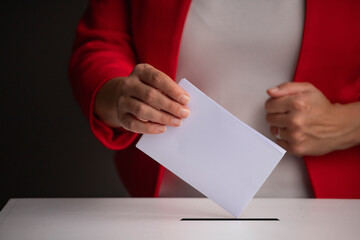 Obraz premium The voter holds his vote ballot paper and places it in the ballot box. Election concept.