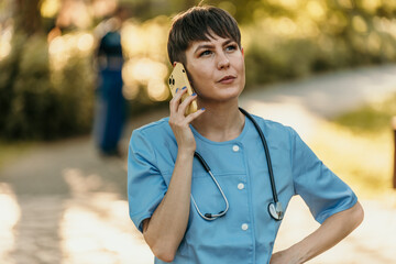 Confident female doctor using smartphone in park during break