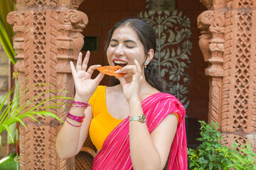 Young beautiful indian woman enjoy eating indian sweet jalebi. Sugar dessert. Food of india.