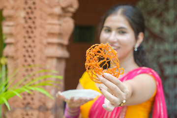 Young beautiful indian woman enjoy eating indian sweet jalebi. Sugar dessert. Food of india....