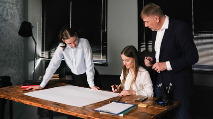 Professionals collaborate on a project in a modern office setting during daytime hours