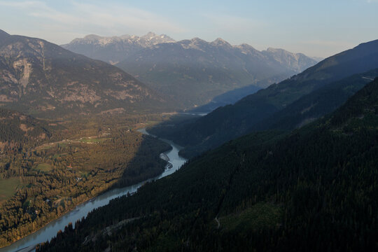 Tranquil scene of mountain range, valley and river at sunset