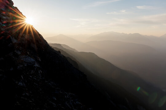 Sunset and sun star on far off mountain range
