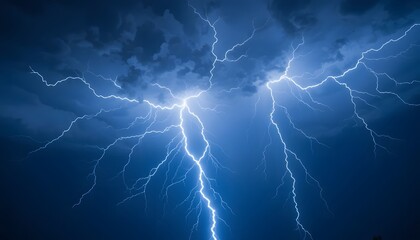 Fototapeta premium Powerful blue lightning strikes illuminate a dark stormy sky