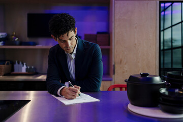 Entrepreneur reviewing contract at modern kitchen workspace