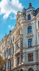 Obraz premium Ornate, light beige, multi-story building, detailed facade, blue sky, puffy clouds