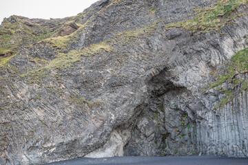 Hexagonal basalt columns outside Halsanefshellir cave on the Reynisfjara black sand beach on...