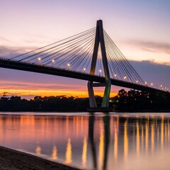 Obraz premium Cable-stayed bridge sunset river reflection