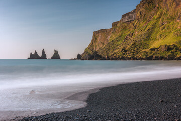 Reynisdrangar basalt sea stacks and the mountain Reynisfjall seen from Víkurfjara Black Sand Beach on Iceland's South Coast