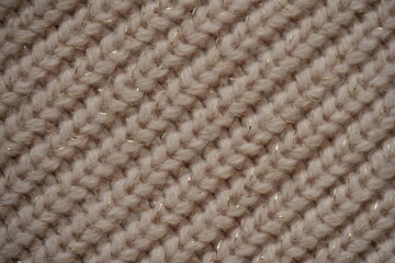 beige knitted wool fabric with shiny thread, close-up texture of soft hand-knitted textile, warm cozy pattern with subtle glitter, macro background