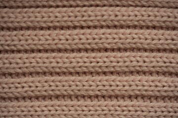Naklejka premium soft pink texture of knitted wool fabric as a background, smooth symmetrical lines of hand-knitted needlework pattern 