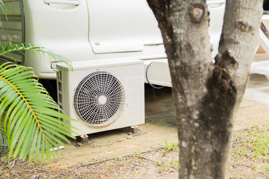 An air conditioner compressor unit  installed on the outside of the RV accommodation in a resort