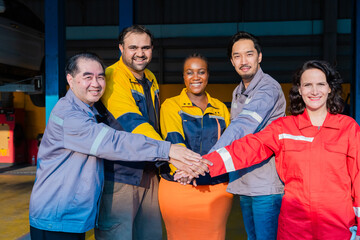 Team of mechanics stacking hands in unity at garage workshop, symbolizing cooperation, garage small...