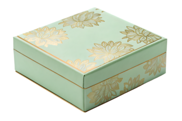 A light green square box with golden flower designs on the top and sides on a dark background