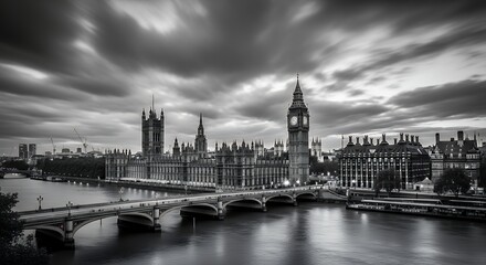 Naklejka premium Big Ben and Houses of Parliament by River Thames in London, UK, with a black and white long exposure creating smooth water and streaky clouds.