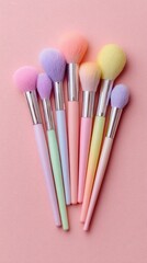 Fototapeta premium Pastel makeup brushes clustered on a pink surface