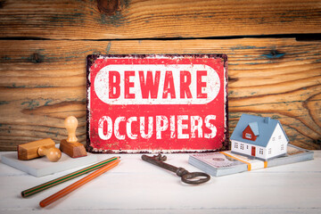 Real estate security concept with beware Occupiers warning sign and house model