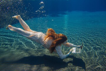 Businesswoman working on laptop underwater in swimming pool