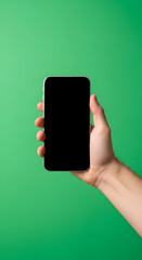 Hand holding a modern mobile device with an empty screen, perfect for content on a vibrant green background