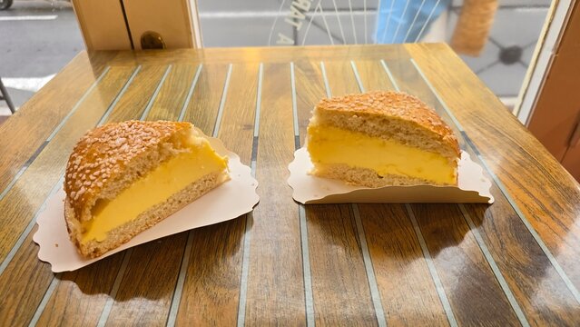 Traditional tarte trop&eacute;zienne dessert with cream filling on a wooden table in a bakery of Saint-Tropez, France. September 2025