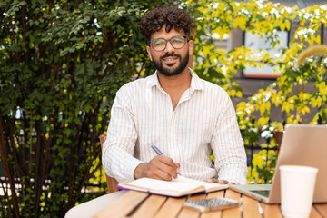 Young businessman taking notes while working outdoor