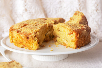 homemade apple streusel cake on white ceramic cake stand.