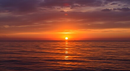 Fototapeta premium Stunning sunset over ocean with vibrant colors and reflection