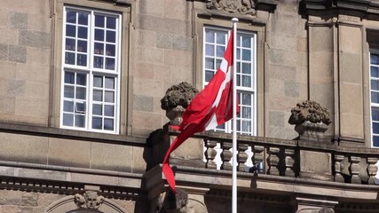 Close-up of the Danish flag fluttering in the wind in front of the Parliament building in Copenhagen, Denmark.