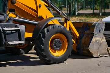 City bulldozer with a large bucket stands on an asphalt road