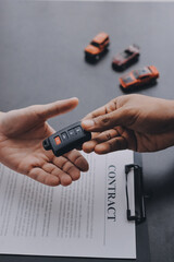 Fototapeta premium Car salesman gave the keys to the customers who signed the purchase contract legally, Successful completion of car sales, Purchase contract and key delivery.