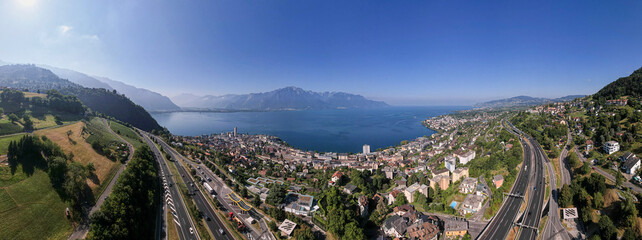 Montreux cityscape aerial panorama on Lake of Geneva in Switzerland with the French and Swiss Alps in the background and A9 freeway in the foreground