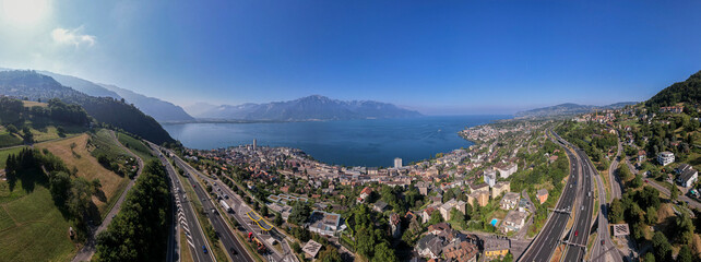 Panorama 180 degrees ity of Montreux along the Lake of Geneva in Switzerland with the French and Swiss Alps in the background and A9 freeway in the foreground
