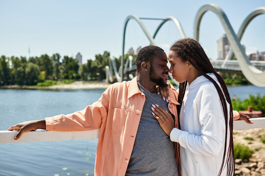 Loving couple enjoying a romantic walk by the serene riverside on a sunny day
